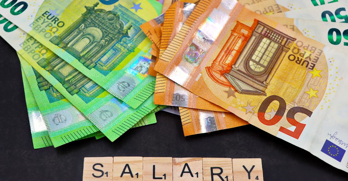 Euro banknotes alongside wooden Scrabble letters spelling 'salary' symbolize financial earnings and payroll.